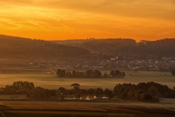 Nebelschwaden im Tal der Nidda im Licht der aufgehenden Morgensonne über Ober Mockstadt.